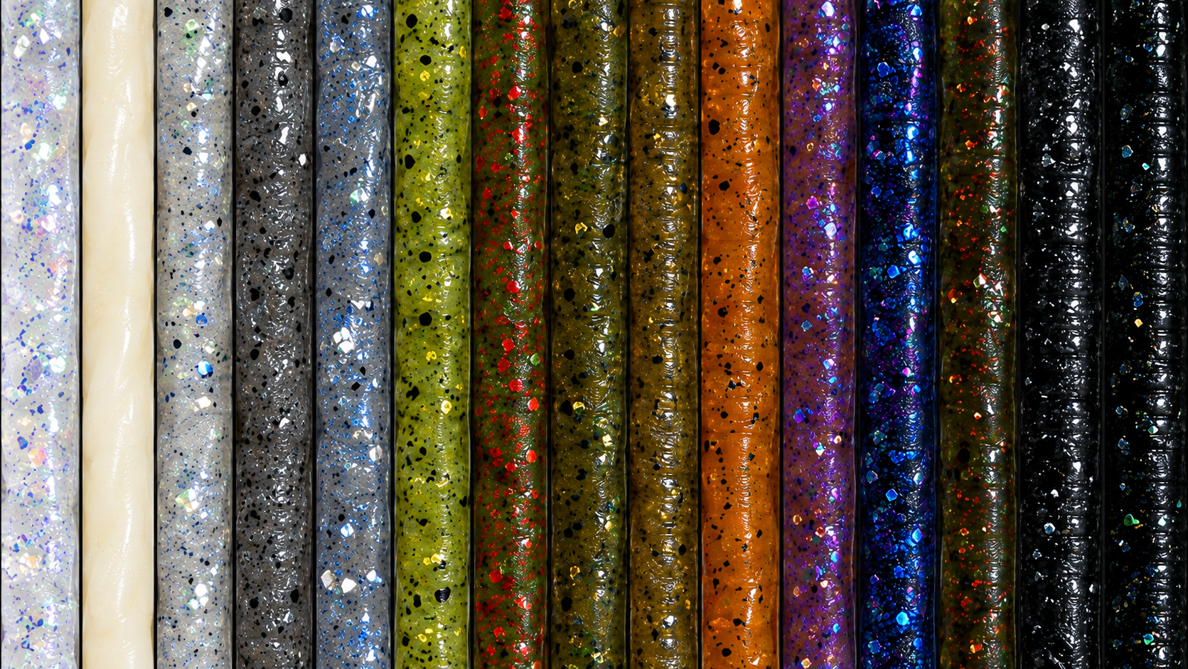 Vertical rows of soft-plastic stick baits in a full color range, from translucent pearl and ghost shad through green pumpkin, brown, orange, purple, and black